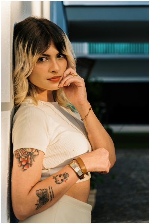 A fashionable woman with tattoos poses confidently