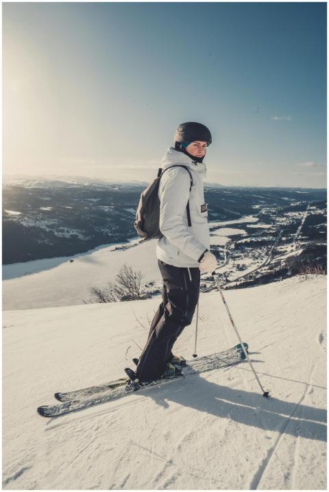 A skier in winter clothing enjoying a sunny day on