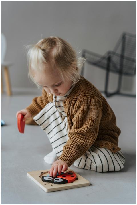 Cute child sitting indoors, focused on playing wit
