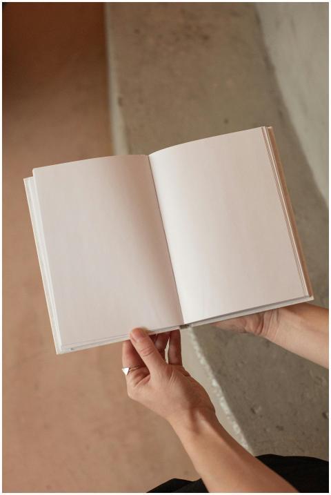 From above of unrecognizable female holding book w