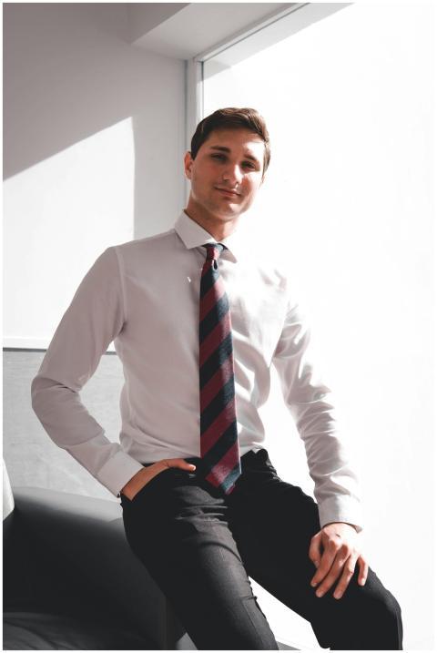 Young man in formal business attire sitting confid