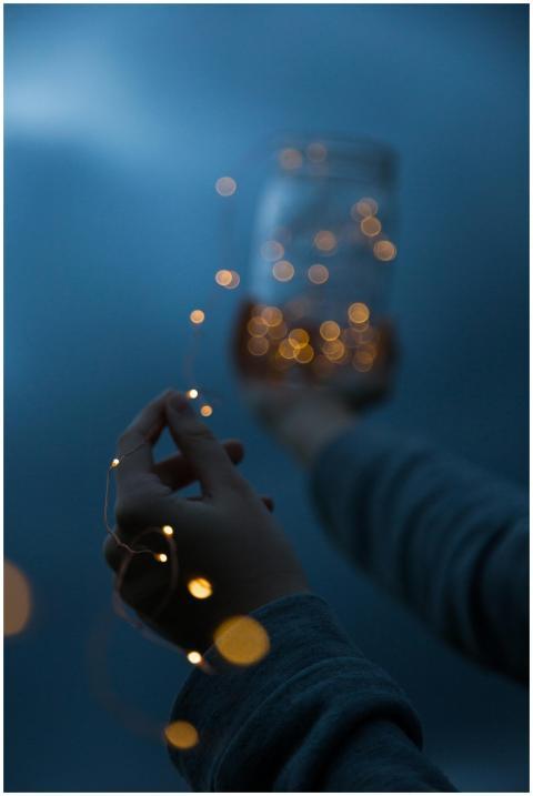 Hands holding a jar with glowing lights, creating