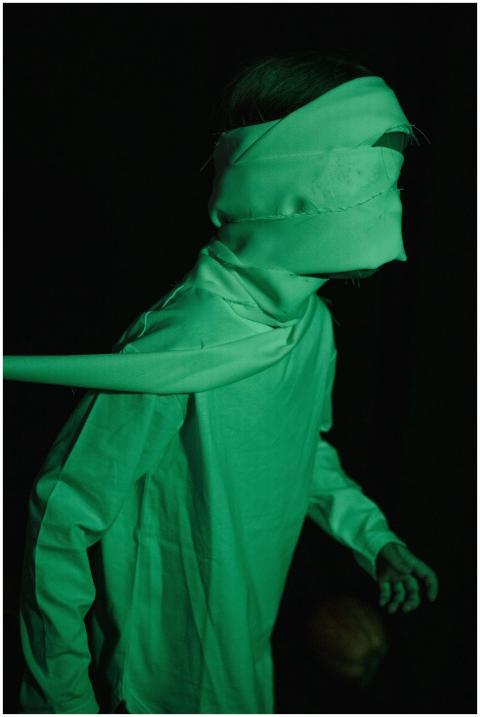 Kid dressed as a mummy for Halloween in a dark set