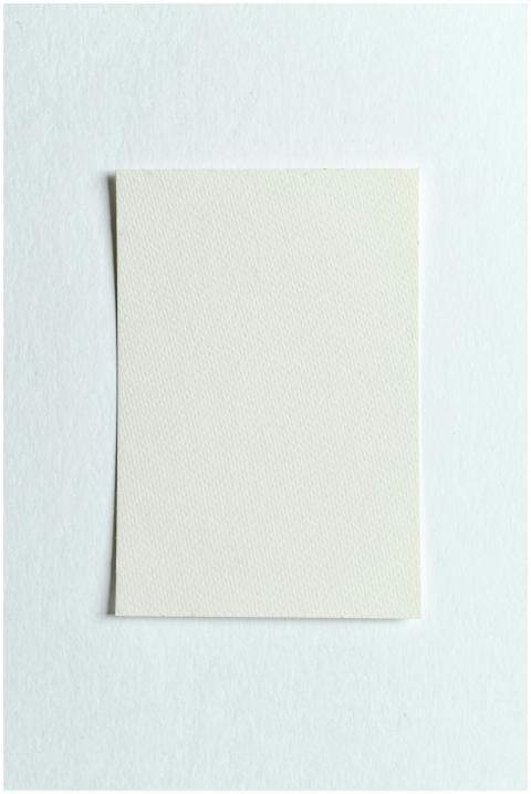 Top view of a white paper sheet on a textured whit