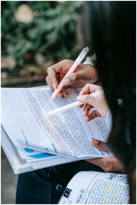 Close-up of students highlighting notes in textboo