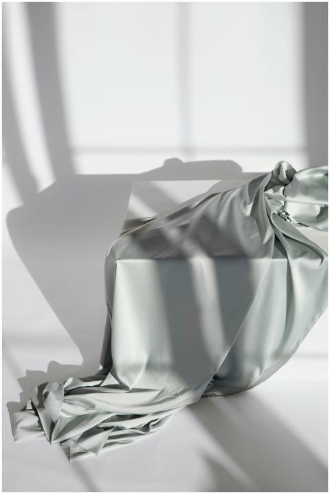 Silk fabric draped gracefully over a table, castin