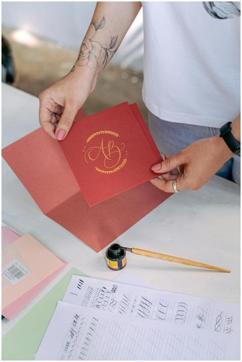 Person crafting a handmade invitation with calligr