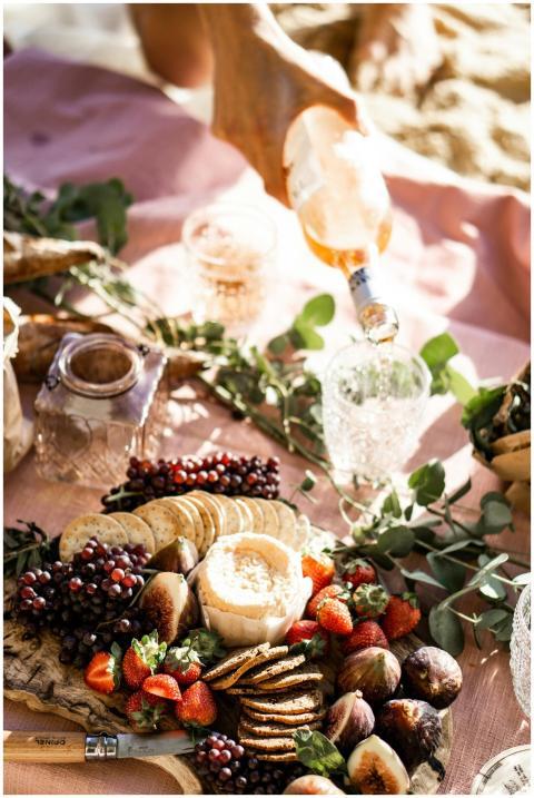 A stylish outdoor picnic with wine, cheese, figs,