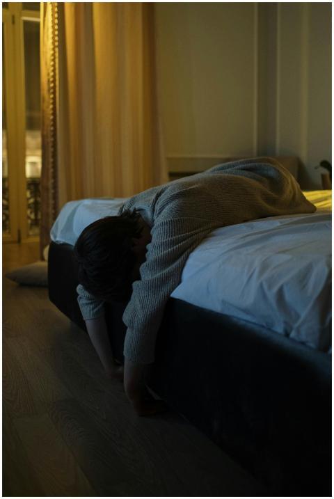 A person with gray long sleeves lying tiredly on a
