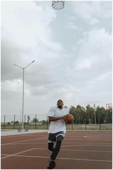 Athletic man dribbling basketball on an outdoor co