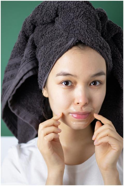 Portrait of a young woman with a head towel applyi