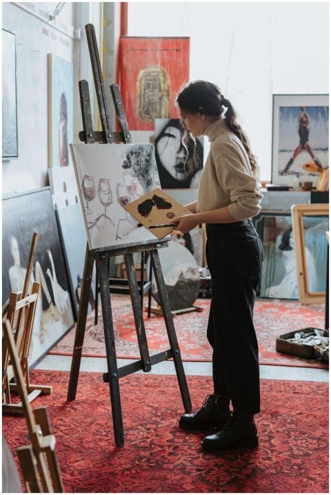 Female artist painting on canvas in a vibrant stud