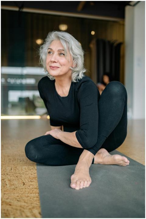 Elderly woman practicing yoga indoors, promoting w