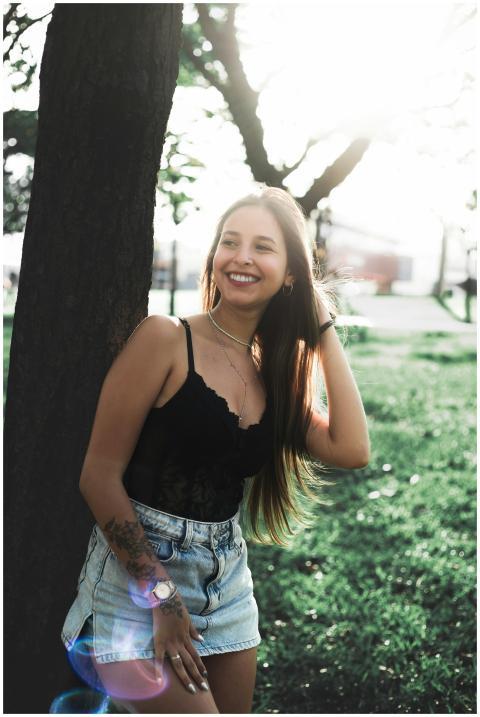 A young woman in casual attire smiles while standi