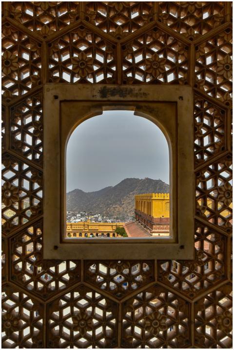 An architectural view through a patterned window a