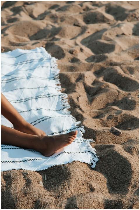Close-up of woman sunbathing on a sandy beach with