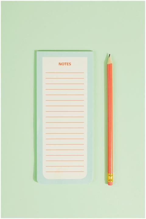 A minimalist image of a pastel notepad and pencil