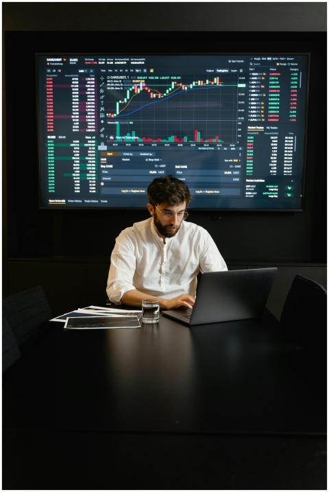 A focused man analyzing stock market trends on a l