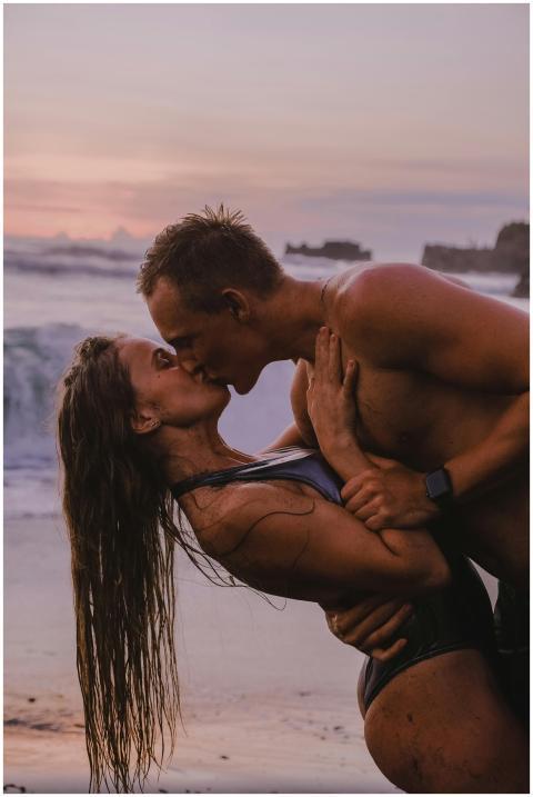 Couple sharing a passionate kiss on the beach duri