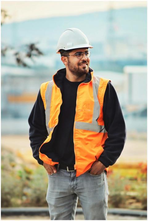 Smiling construction worker wearing safety vest an