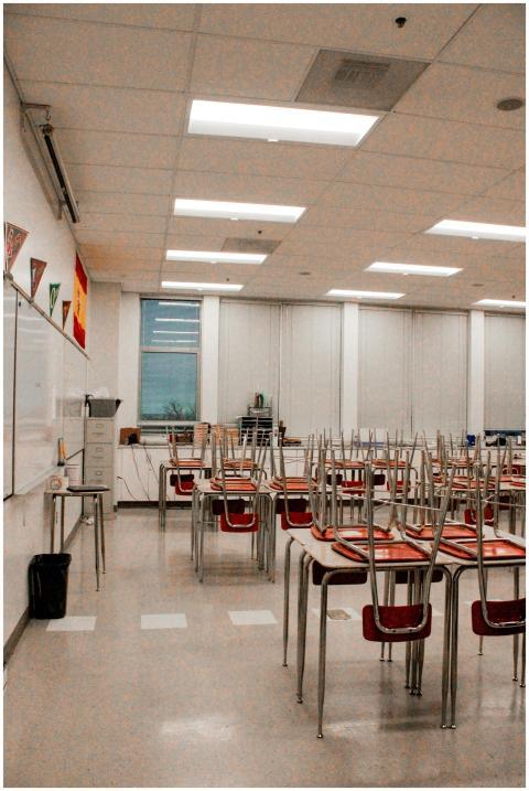 Empty classroom interior with desks and stacked ch