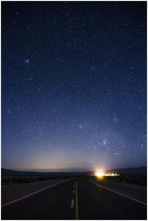 A scenic road leading into a starry night sky in S