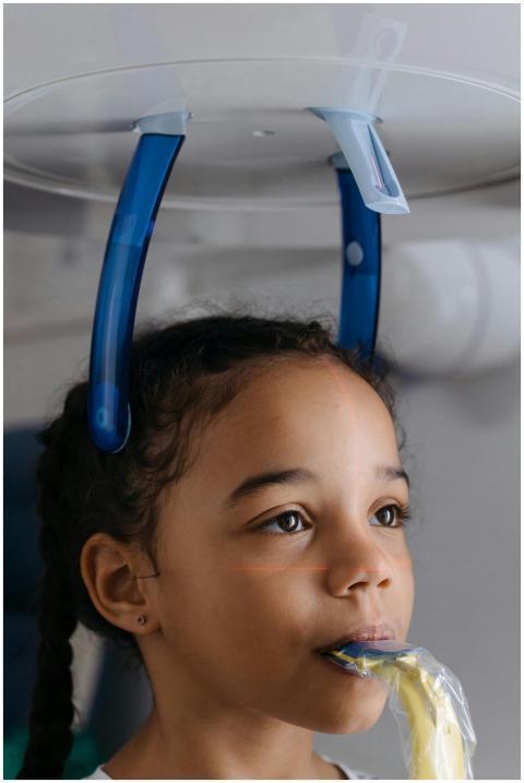 A young girl receiving a dental x-ray checkup in a