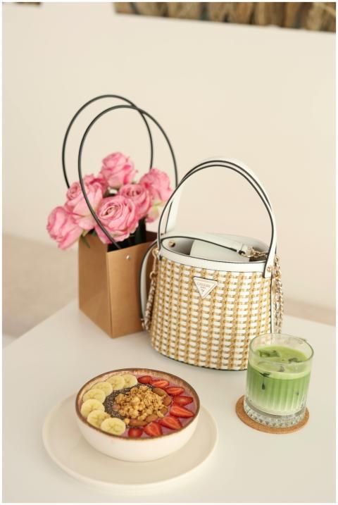 Fashionable breakfast table with fruits, handbag,