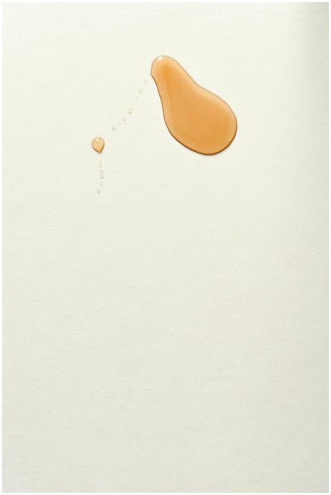 Close-up of a maple syrup droplet staining a white