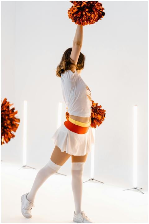 Cheerleader in a vibrant outfit performing energet