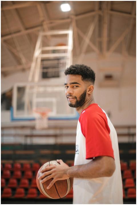 Focused young male basketball player holding a bal