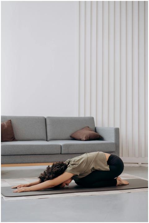 Young woman practicing yoga at home, fostering rel