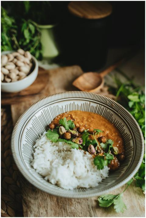 A bowl of vegan lentil curry with rice garnished w