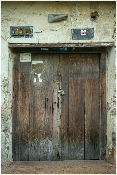 A vintage wooden door with a metal lock, showcasin
