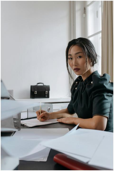 Asian woman focused on paperwork in an office sett