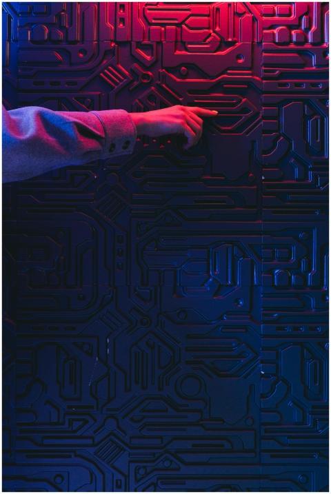 A person's hand interacting with a glowing circuit