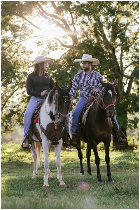 A couple riding horses through a sunlit countrysid