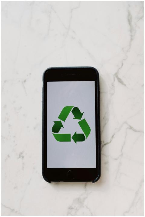 Mobile phone displaying a green recycling symbol,