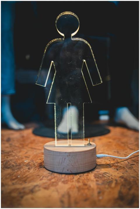 A modern transparent lamp shaped like a female sil