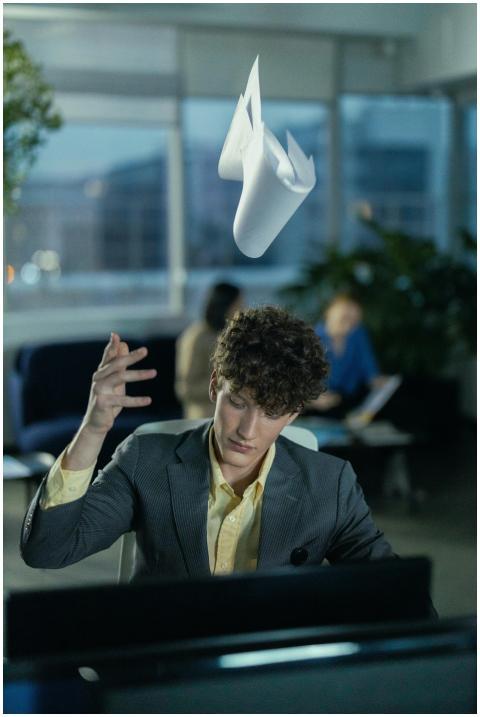 Young office worker in gray suit frustrated, tossi