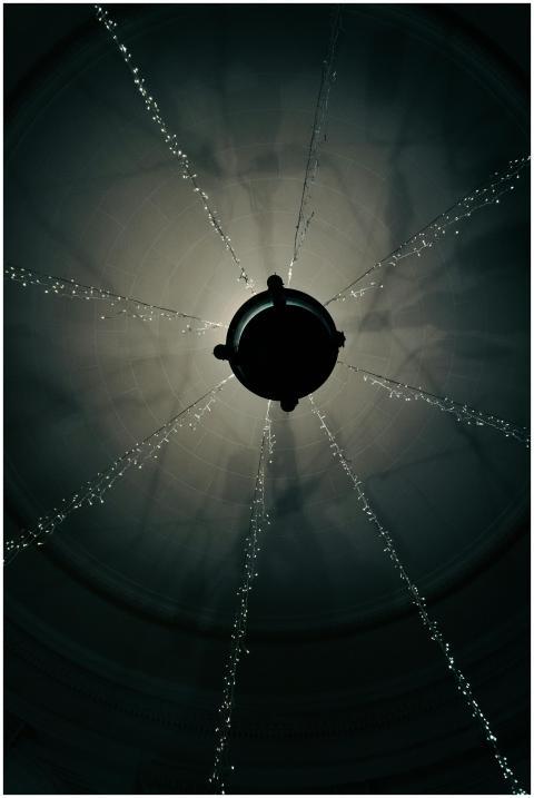 A striking silhouette of a chandelier from below,