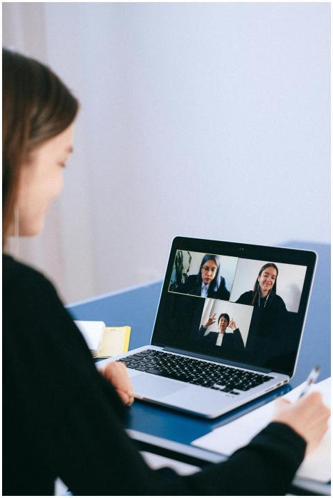 A woman participates in a virtual meeting with col