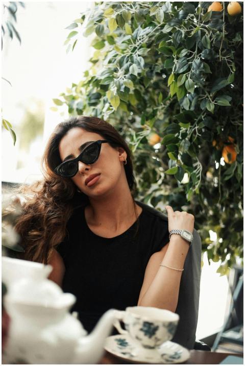 Elegant woman enjoying a sunny day in a Baku cafe,