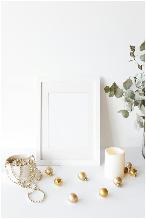 Composition of empty white photo frame placed on w