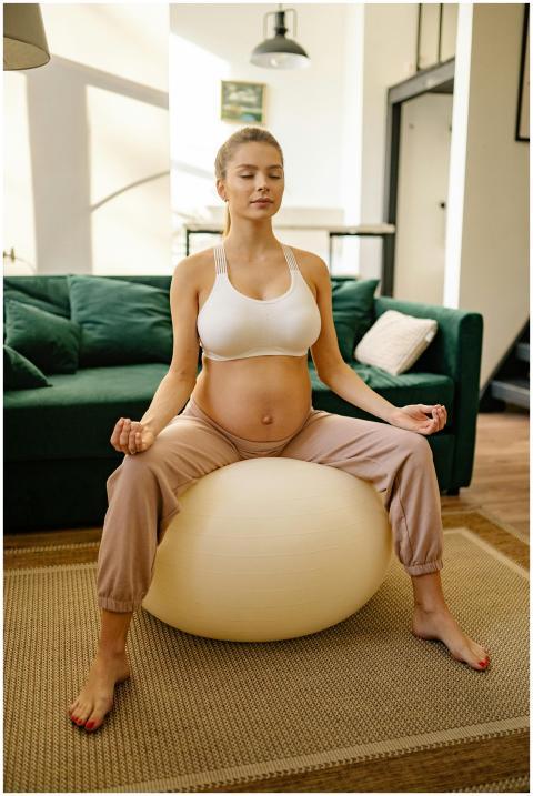 A pregnant woman practices meditation on an exerci
