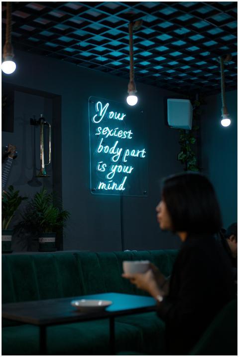 A woman enjoys a drink in a dimly lit café with a