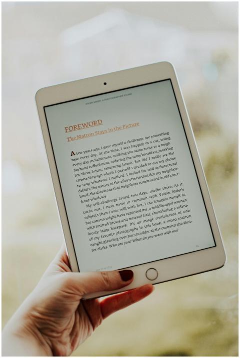 Close-up of a hand holding a tablet displaying an