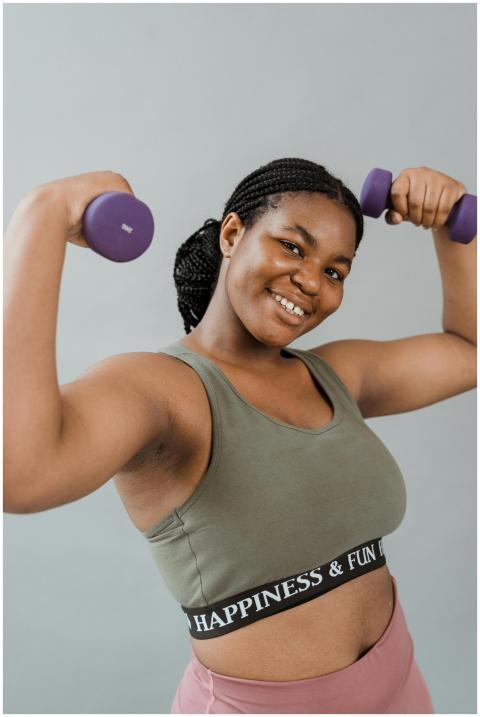 Smiling plus size woman in activewear exercising w