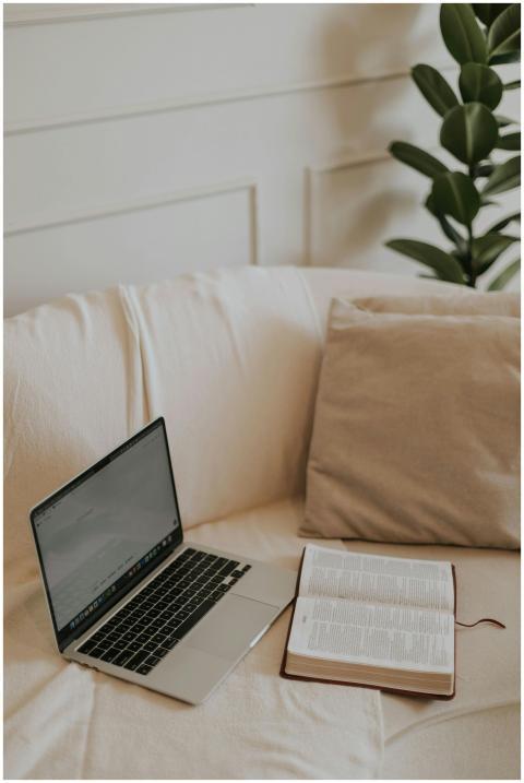 Cozy indoor setup with an open Bible and laptop on