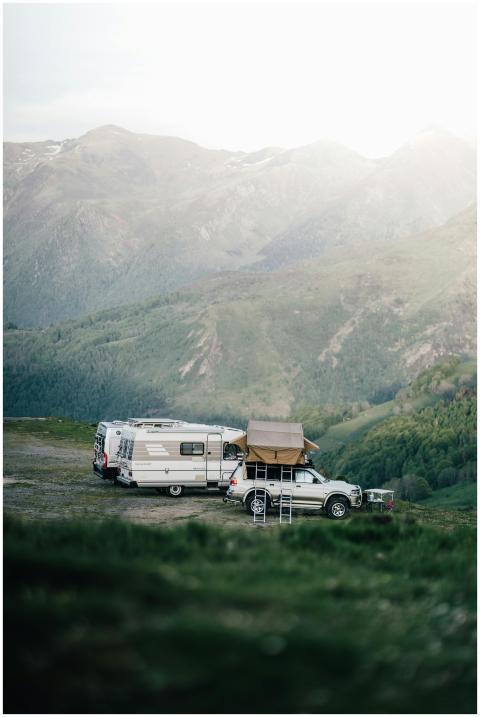 A car and camper van set up camp in a serene mount